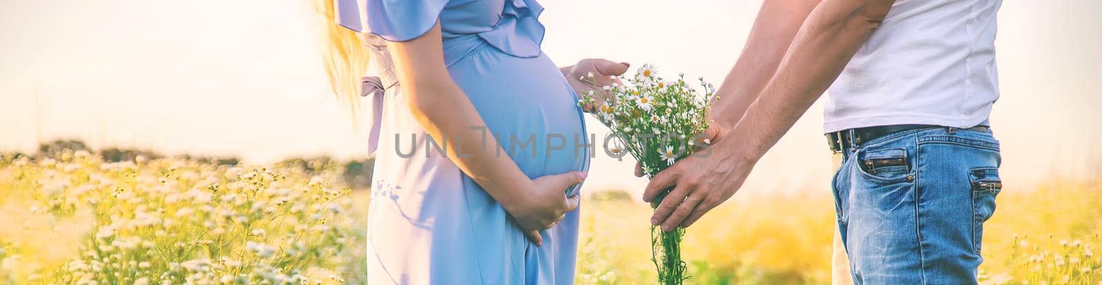 pregnant woman and man gives flowers. Selective focus. nature.