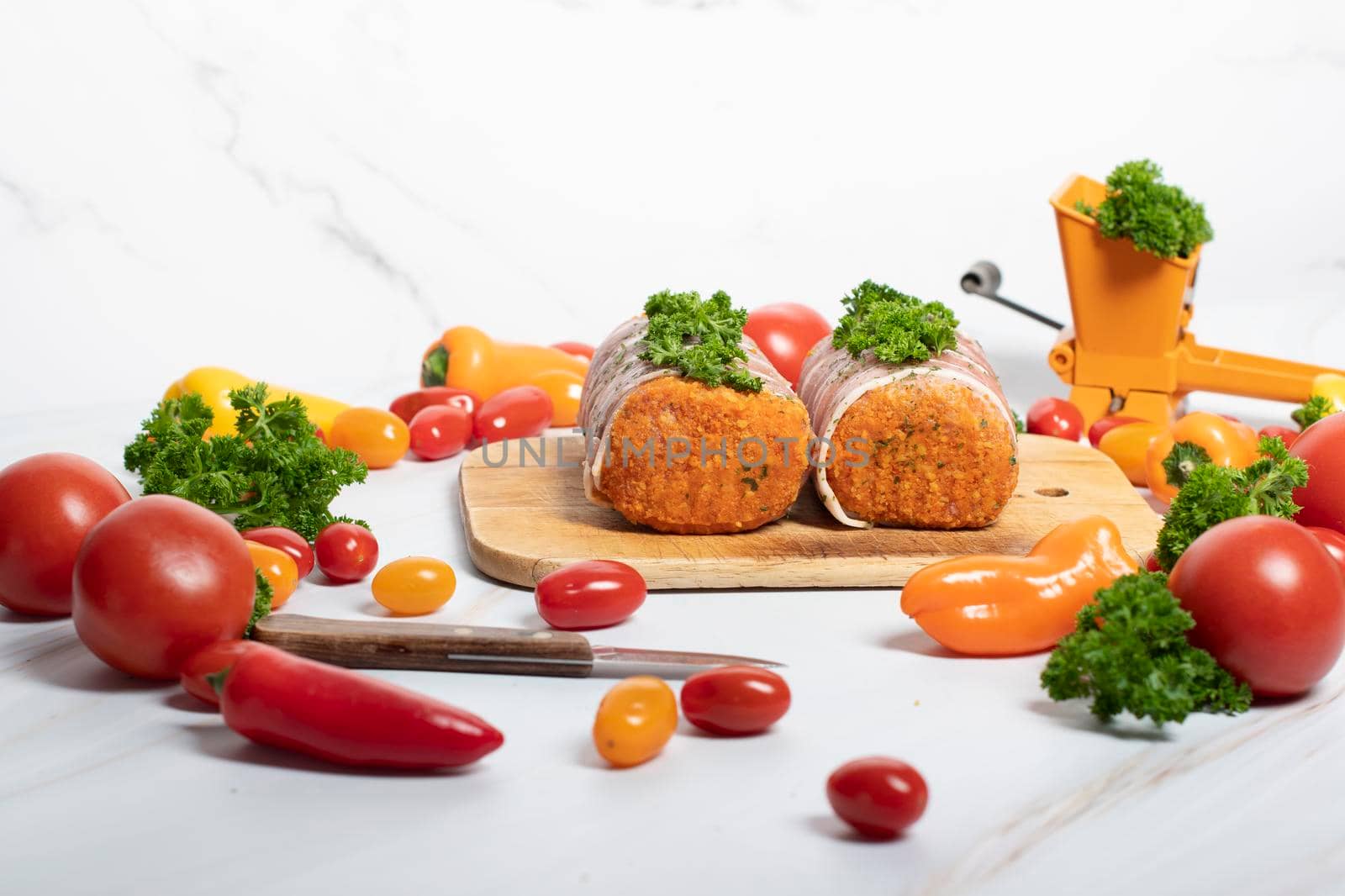 minced meat sausages in bacon with green parsley and fresh vegetables, cherry tomatoes, bell peppers, colorful food . High quality photo