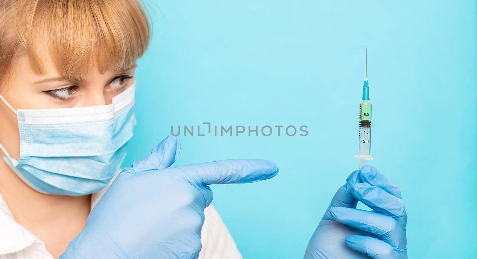 Doctor with a syringe in his hands. Selective focus.