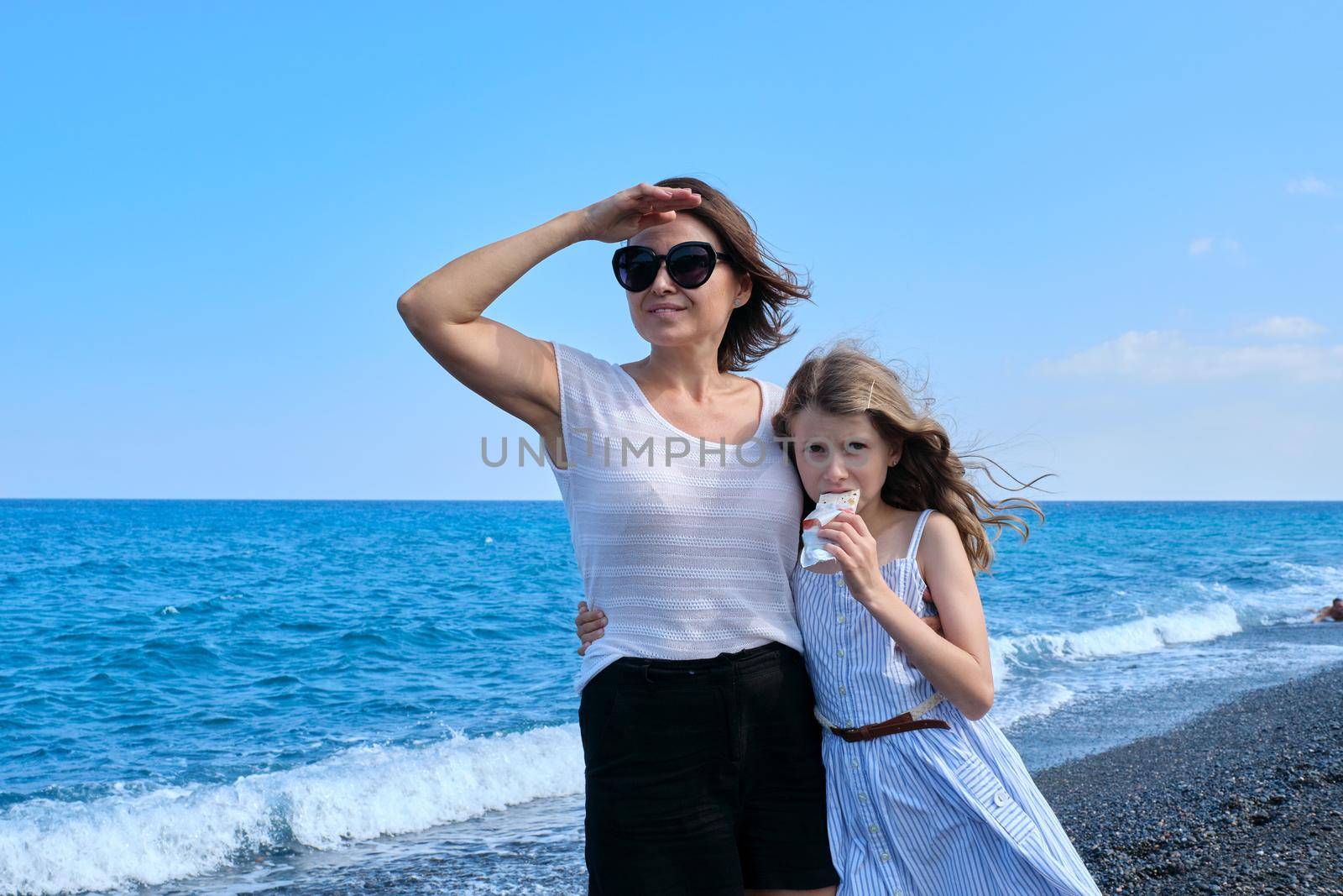 Happy mom and daughter kid hugging together on beach, copy space by VH-studio