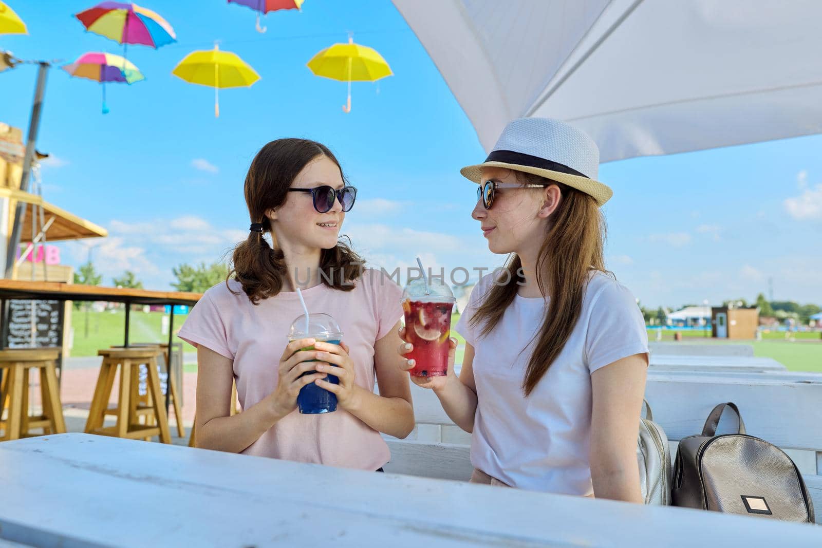 Girlfriends teenagers having fun drinking soft drinks by VH-studio