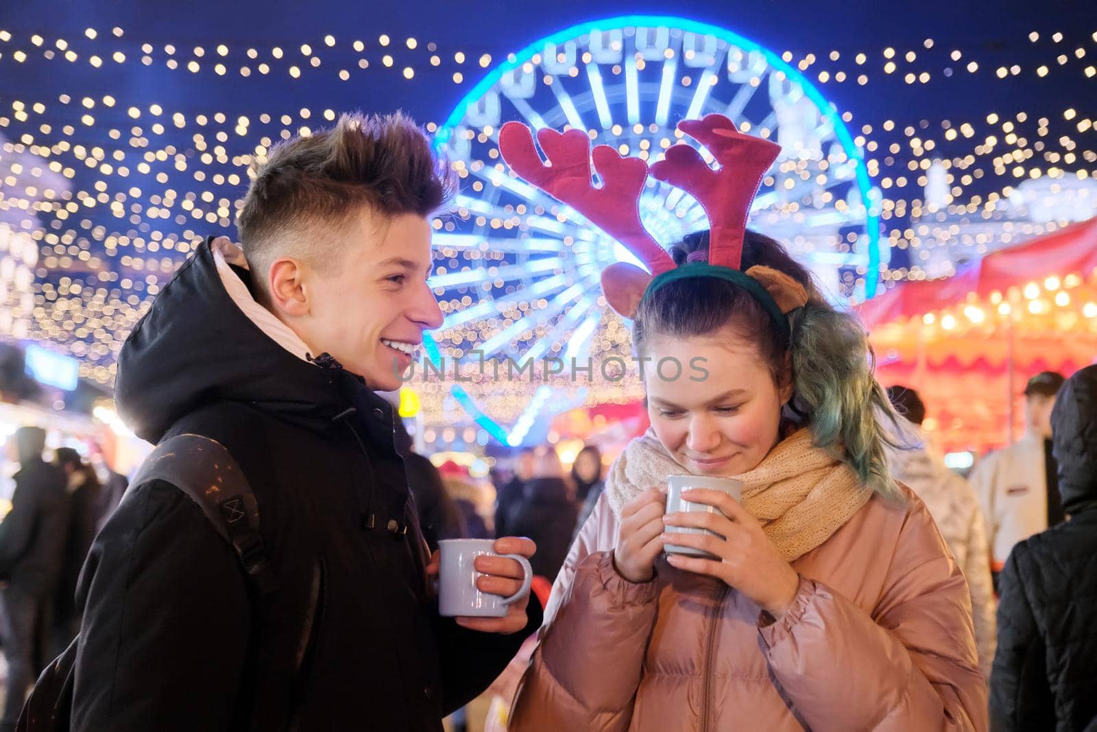 Young people, couple of teenagers having fun at Christmas market by VH-studio