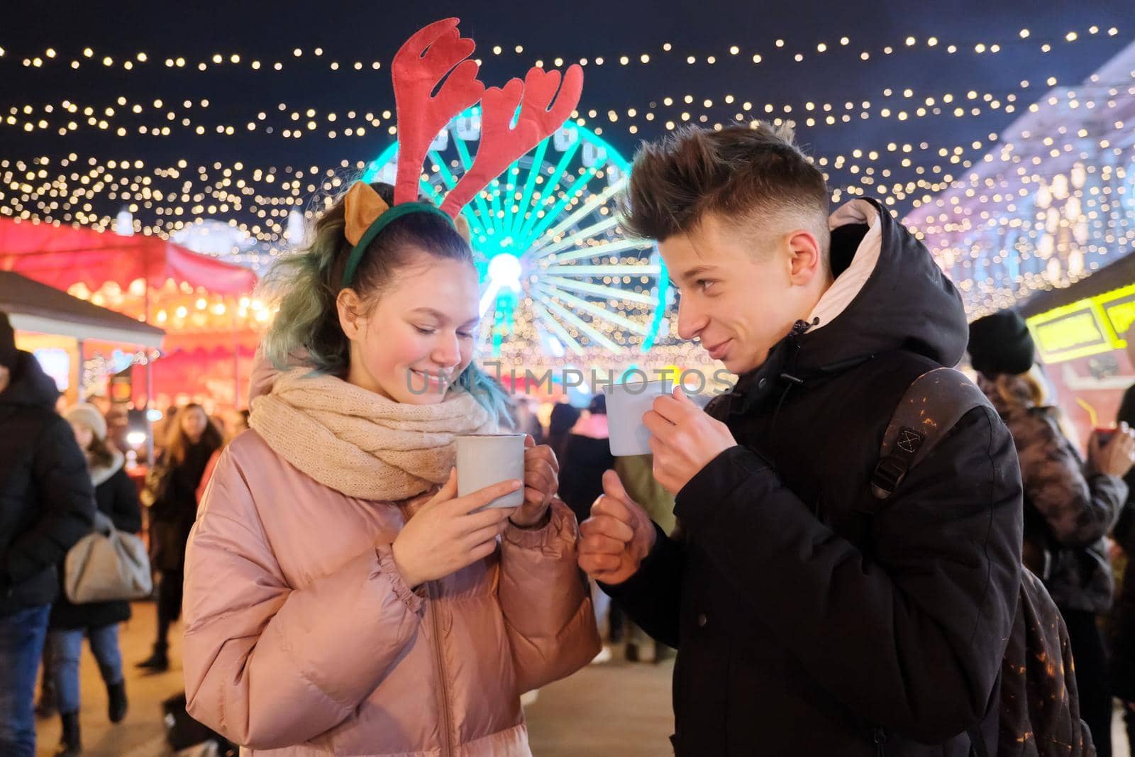 Young people, couple of teenagers having fun at Christmas market by VH-studio