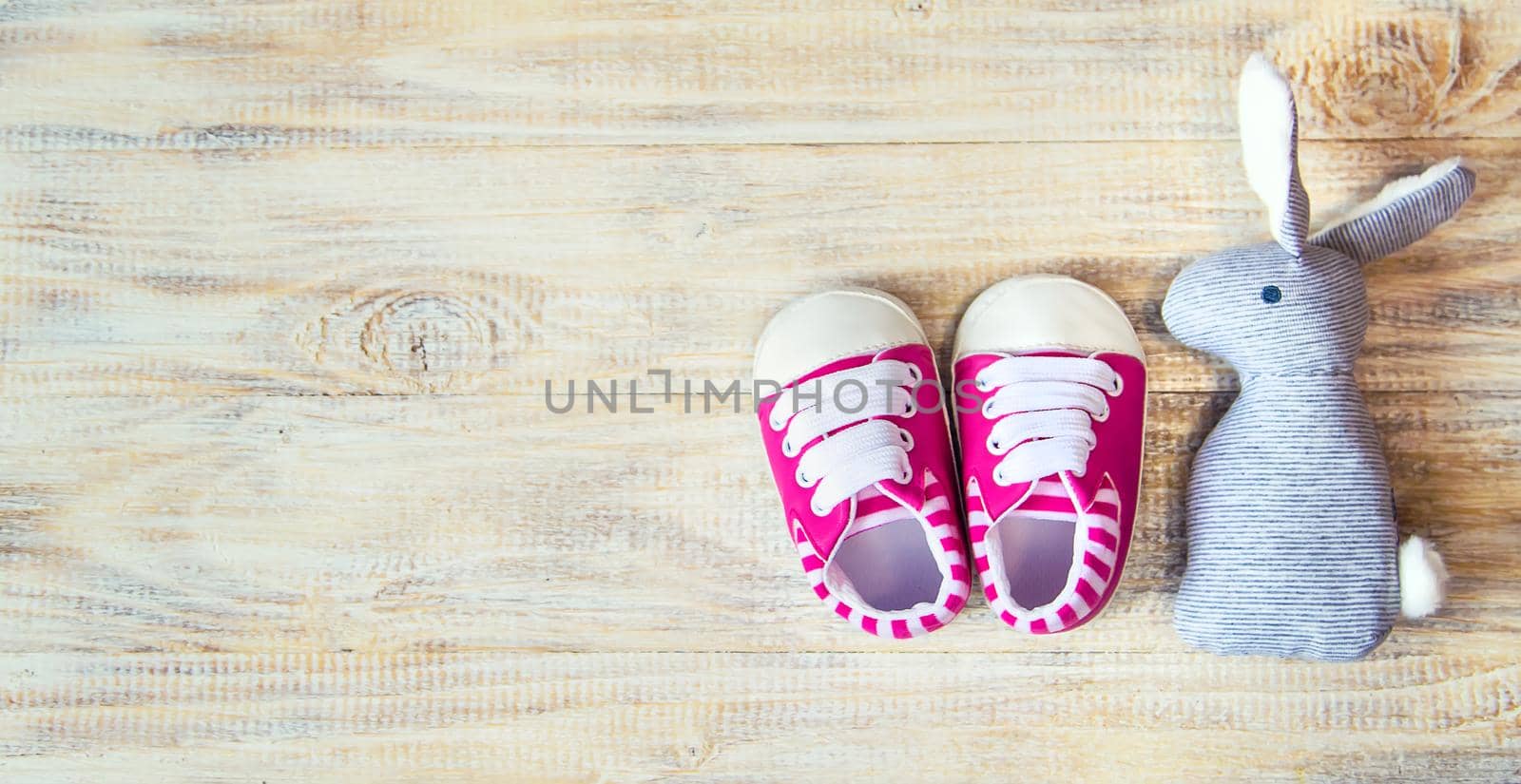 Baby booties and accessories on a light background. Selective focus.