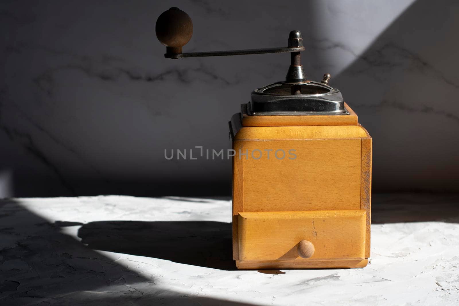 whole roasted coffee beans in the drawer of a vintage wooden coffee grinder in the sun, close up. High quality photo