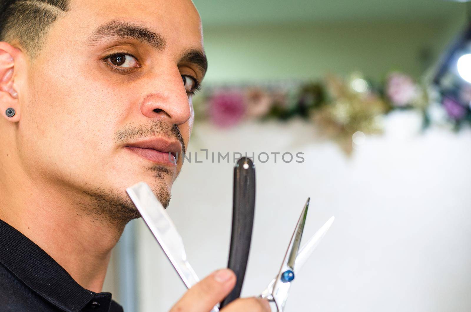 Barber Shop. Barber holds a razor to shave his beard. by Peruphotoart