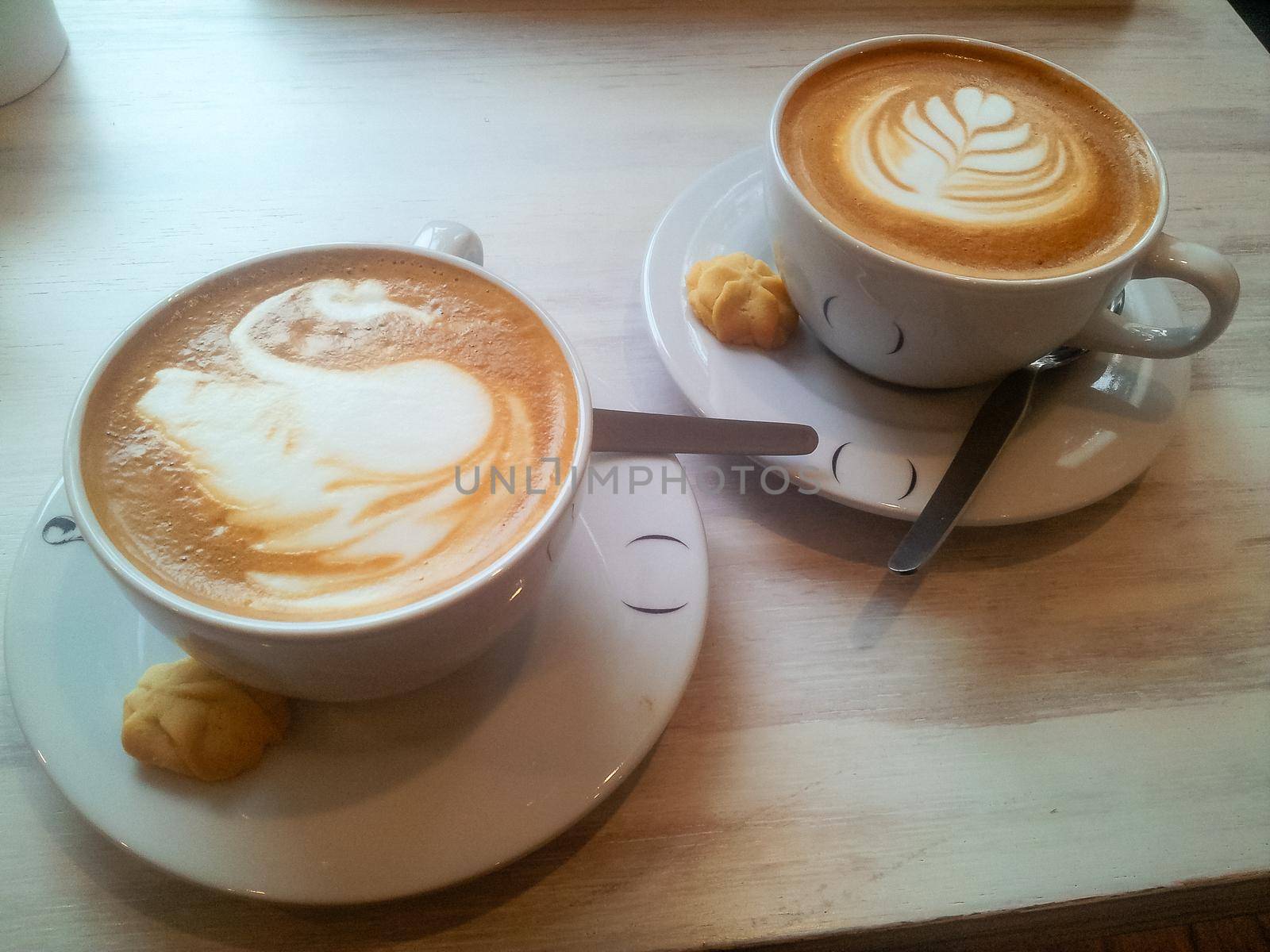The Latte arts coffee. Coffee arts. Two hot coffee set in a white cup on desk or table. by Peruphotoart