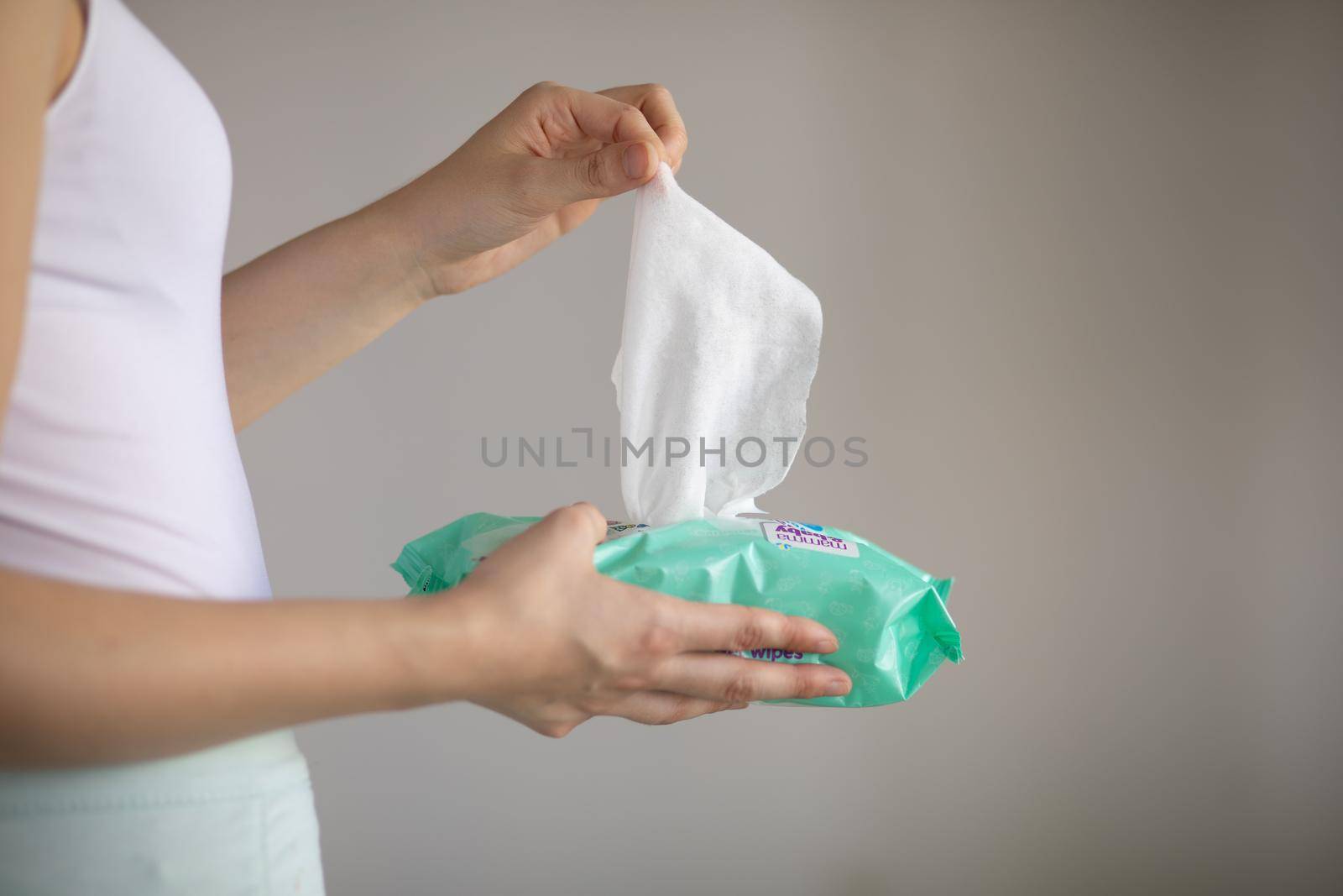 Woman taking wet baby wipes from the packaging - care for clean skin and surfaces by adamr
