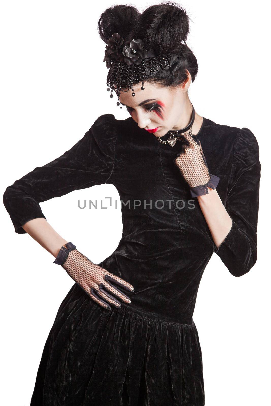 Young beautiful gothic woman with white skin and red lips with bloody drops wearing black collar with spikes. Red smokey eyes. Halloween makeup.