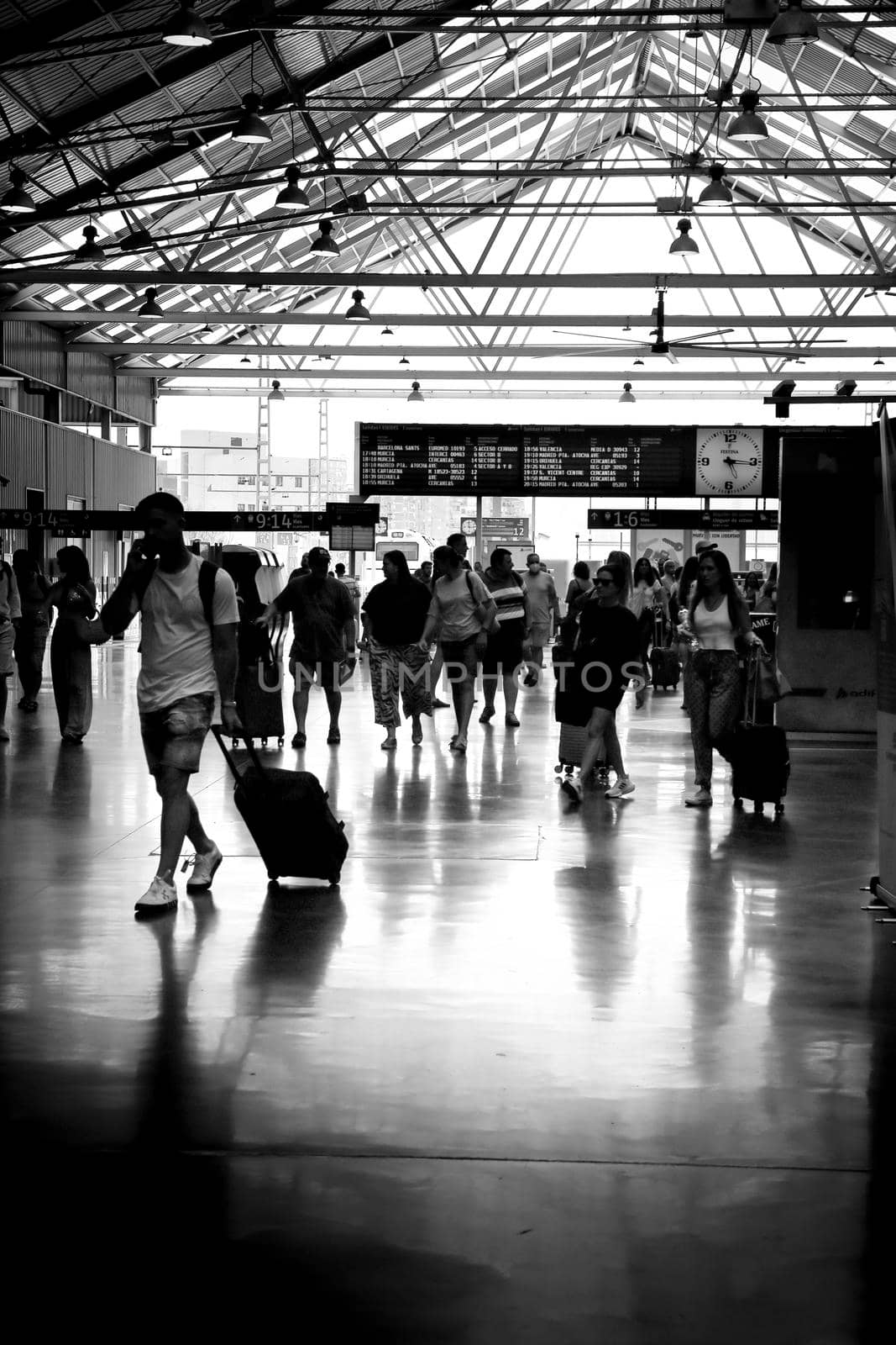 Alicante, Spain- June 24, 2022:Passengers walking through the train station of Alicante with suitcases
