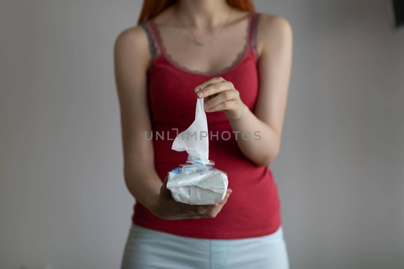 Woman taking wet baby wipes from the packaging - care for clean skin and surfaces by adamr