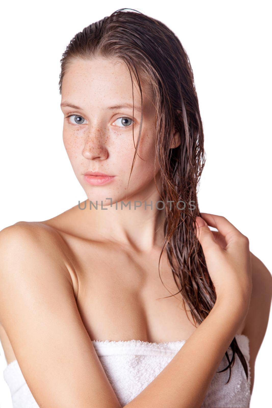 Portrait of a beautiful model with wet hair and clean skin and freckles after shower isolated on white background.