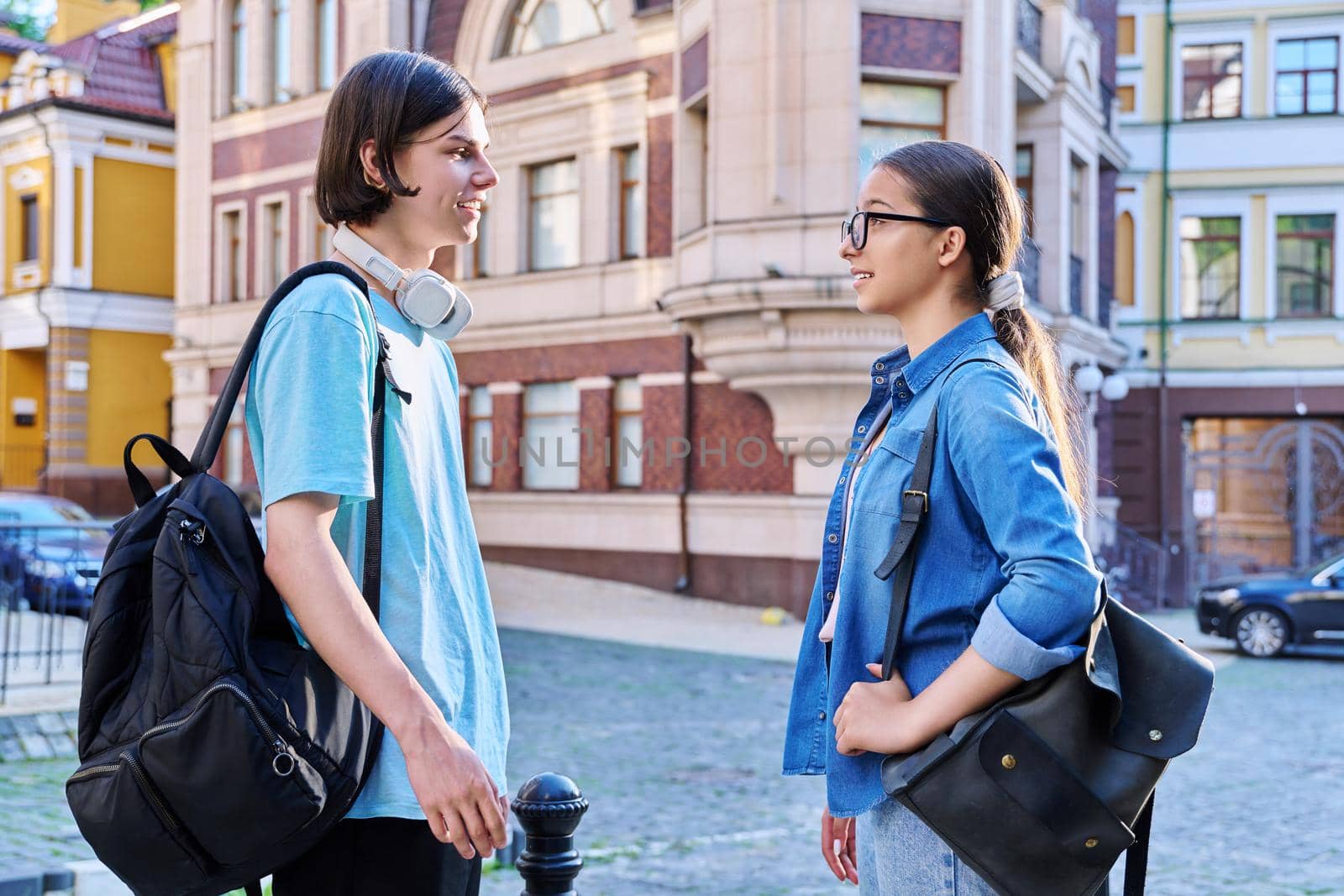 Teenage friends male and female talking on the street of city by VH-studio