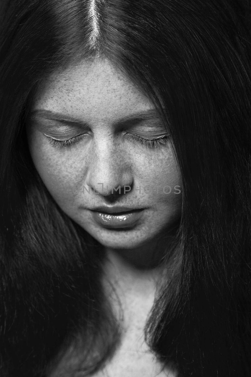 Beautiful fashion model with freckles, makeup and dark hairstyle. .Black and white photography.