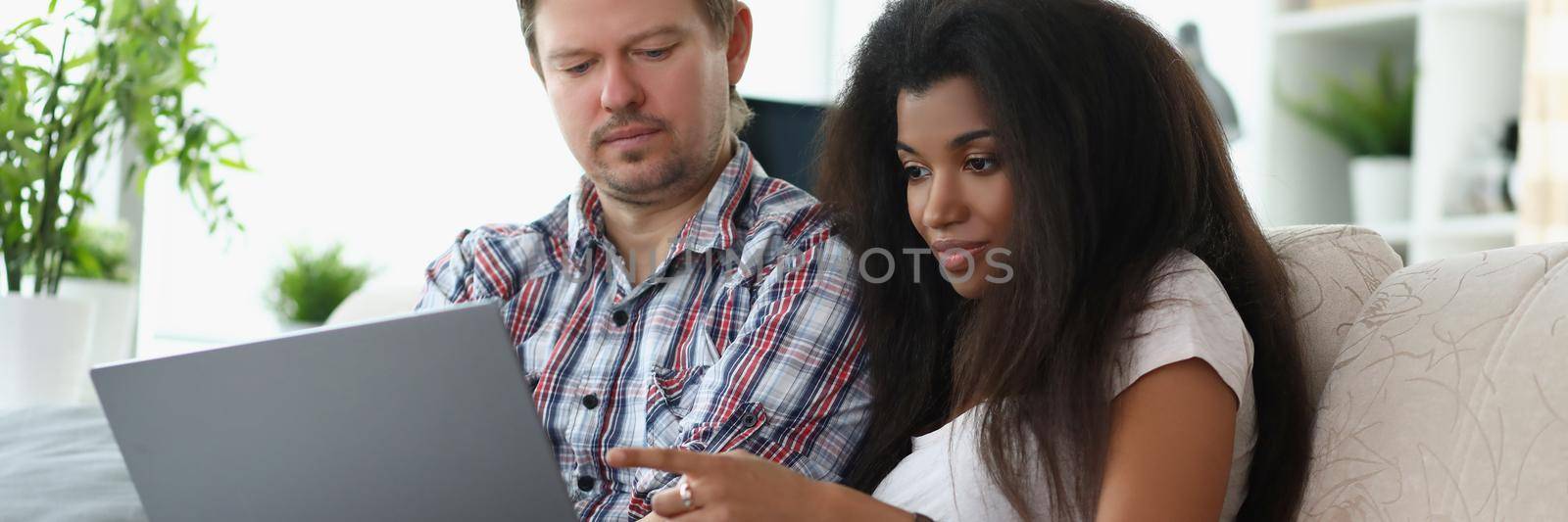 Portrait of middle aged man and latino american woman choosing something online. Couple want to buy furniture via online store. Online shopping concept