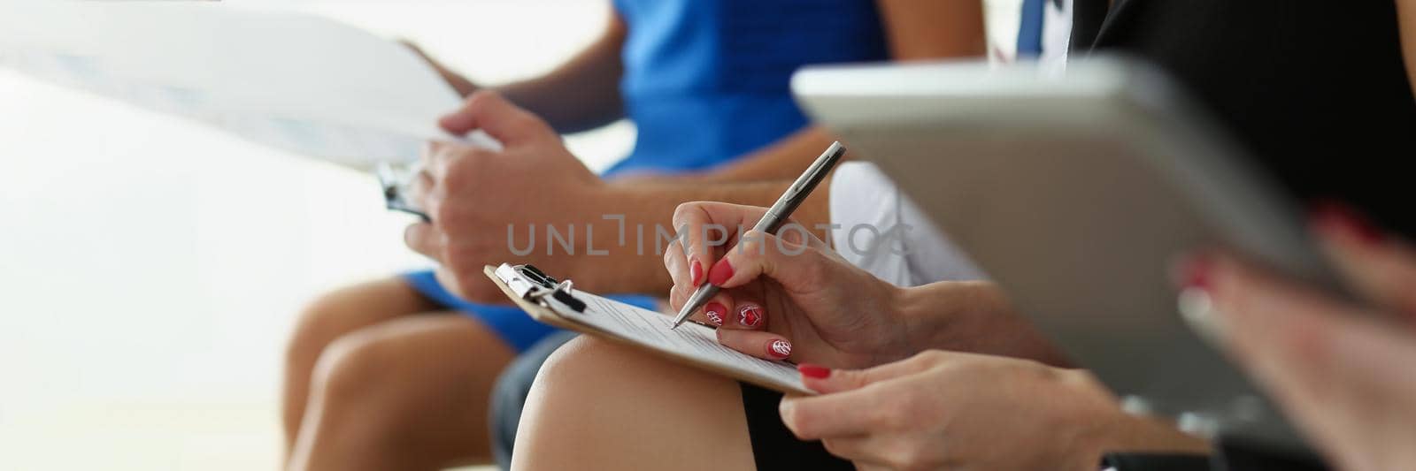 Close-up of group of people hold silver pens and pad ready to make marks while sit in row at seminar training. Executive coaching, presentation concept