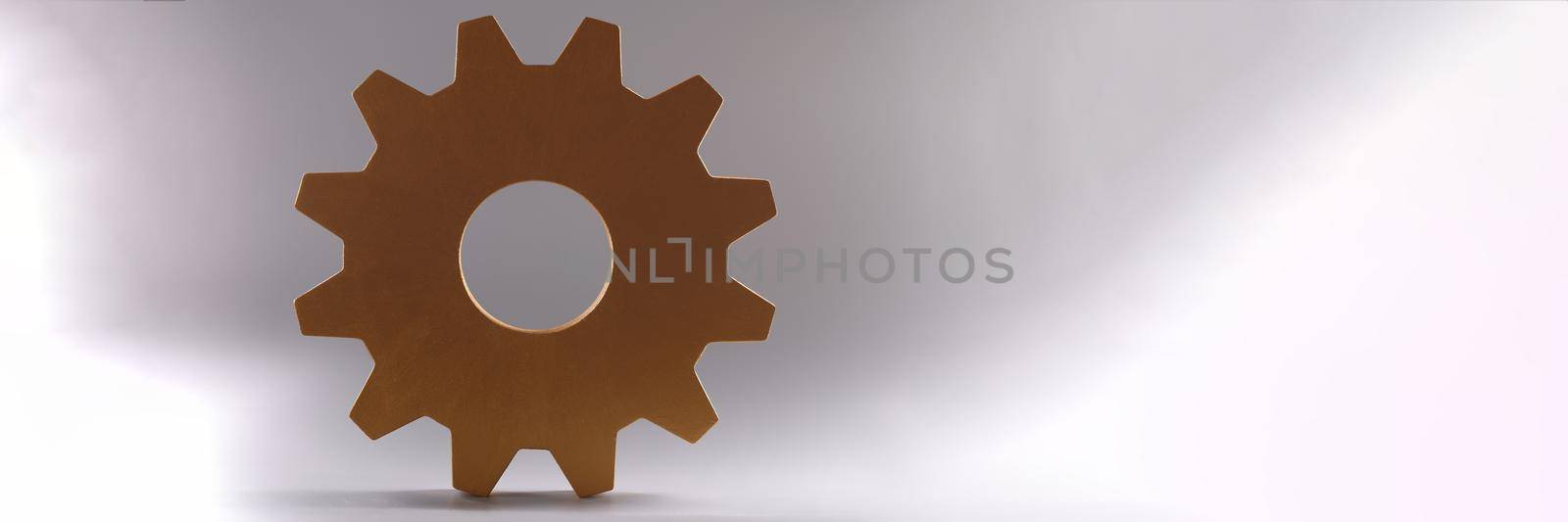 Golden detail of gear wheel of mechanism lying on gray background closeup. Repair of mechanical products concept