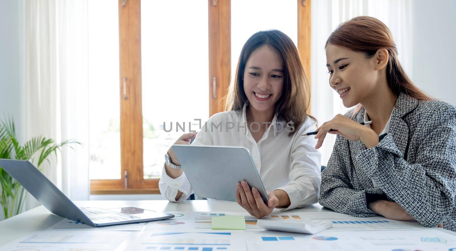 Two young asia business woman working together in office space.