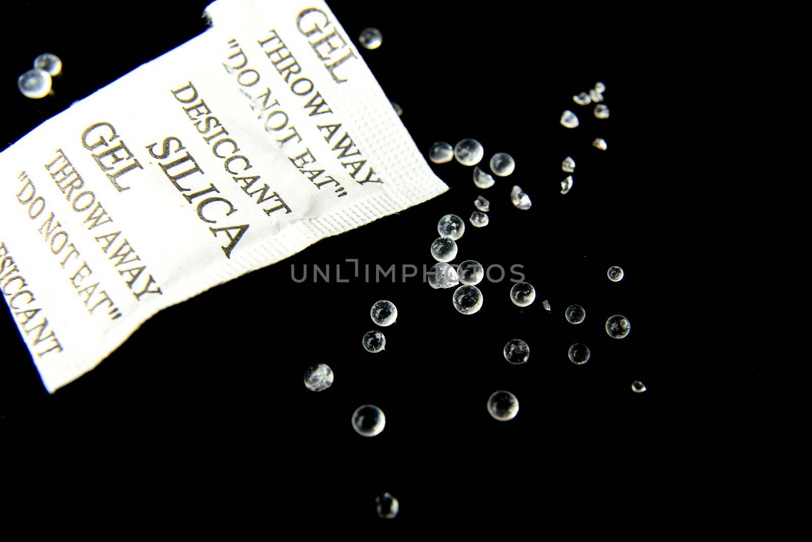 Open packet of Silica Gel Beads on black background by soniabonet