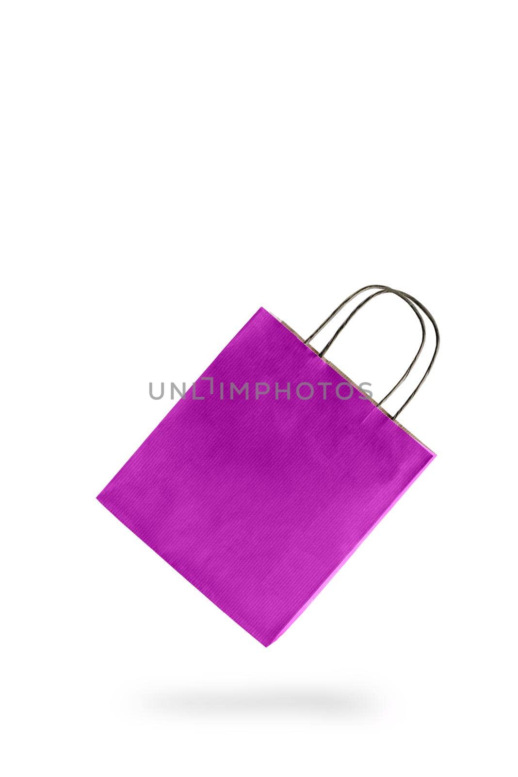 Violet color paper shopping bag on white isolated background. An empty price tag hangs to insert text