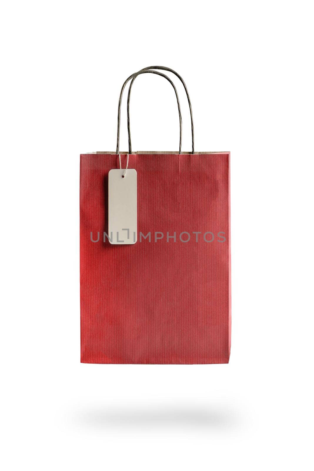 Red color paper shopping bag on white isolated background. An empty price tag hangs to insert text. by SERSOL