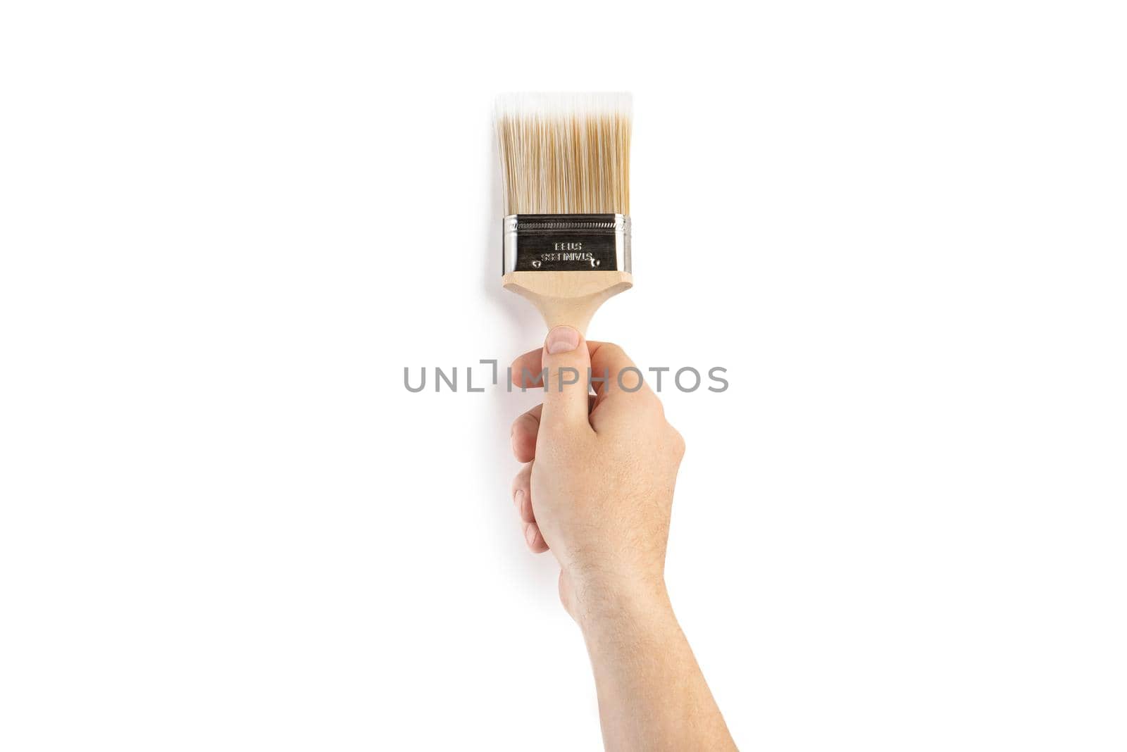 A paint brush in a man's hand. Renovation concept. Supplies and tools for painting walls isolated on white.