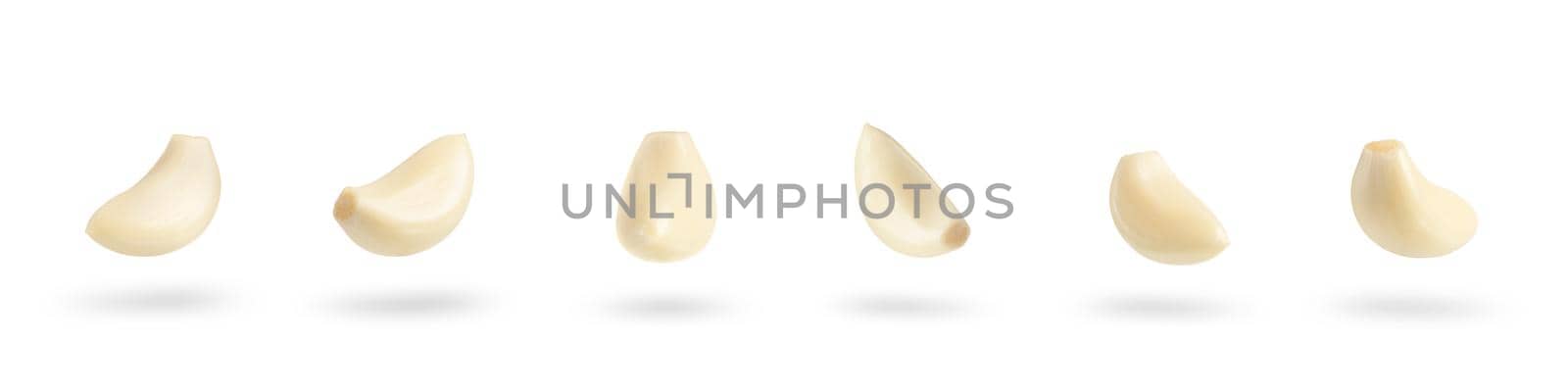 Garlic on a white background. Big set falling peeled clove of garlic falling on white isolated background casting shadow.