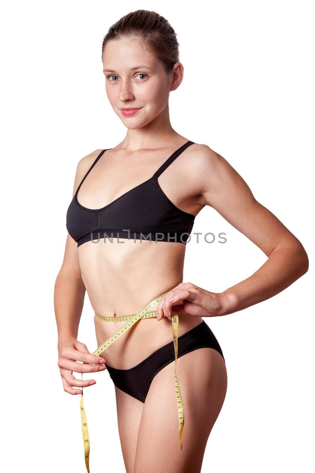 Slim fit happy young woman with measure tape measuring her waist with black underwear, isolated on white background. studio shot.