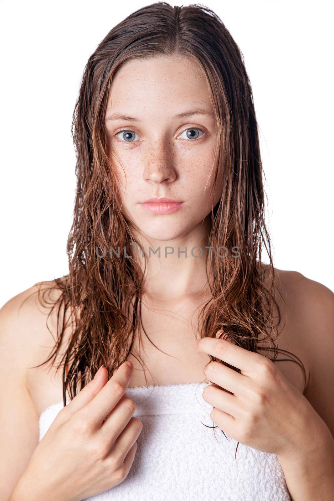 Portrait of a beautiful model with wet hair and clean skin and freckles after shower isolated on white background.