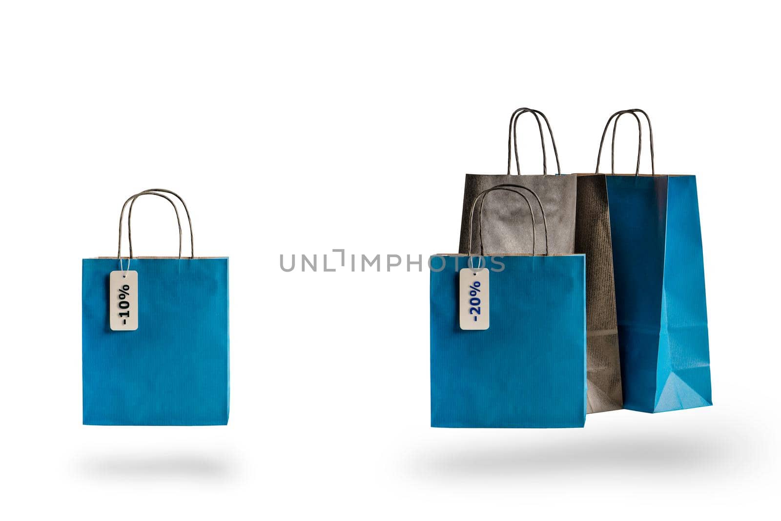 Shopping paper bags of different colors on white isolated background. Discount price tag hanging on sale.
