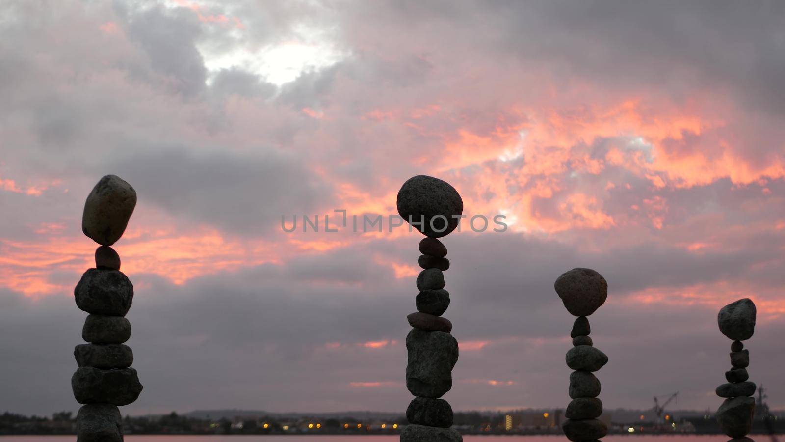 Rock balancing and cloudy dramatic sky on sunset. Stack of stones in balance. by DogoraSun