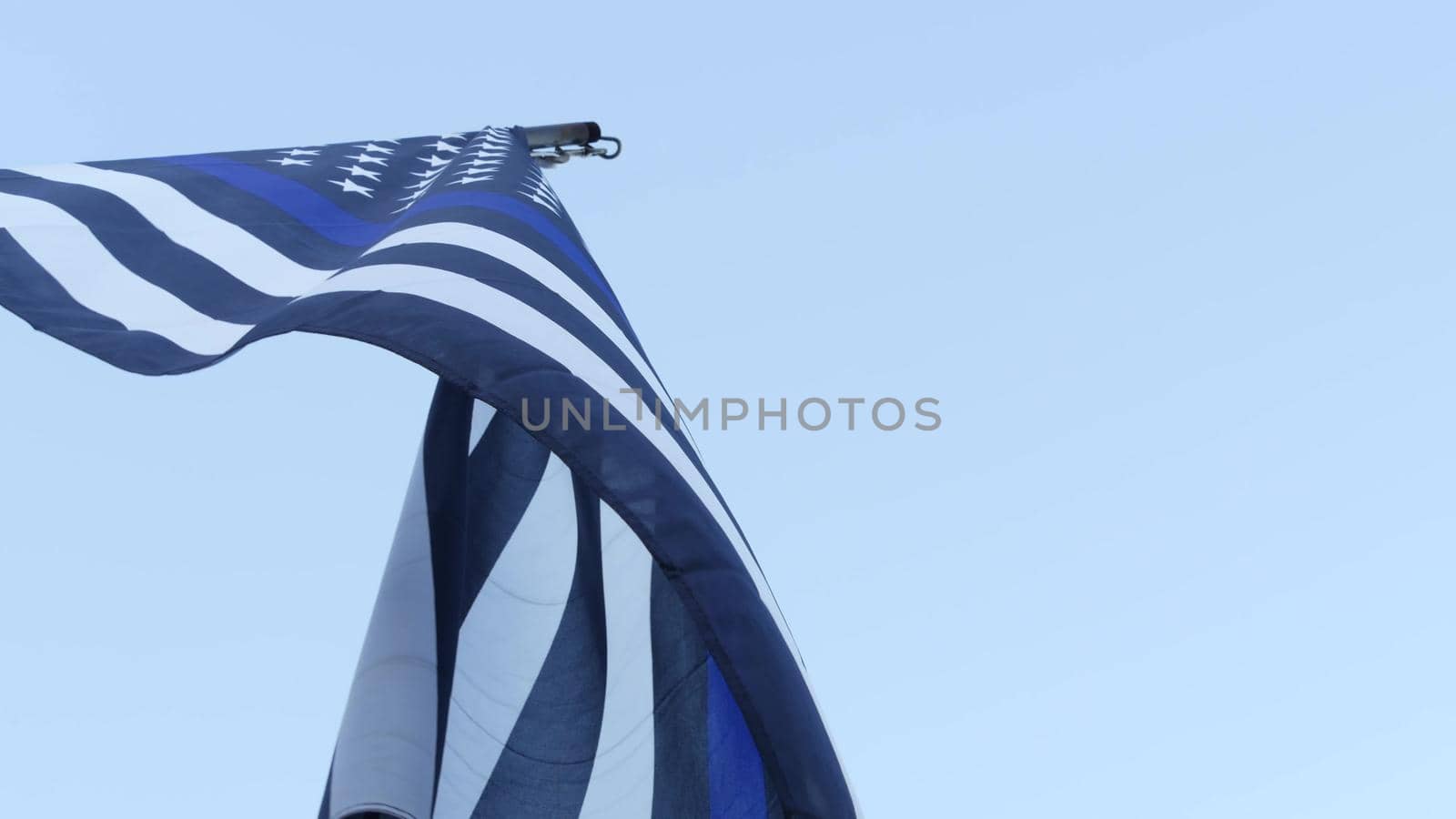 Black white american monochrome flag with blue stripe or line, police support. Solid star-spangled banner waving in wind breeze.