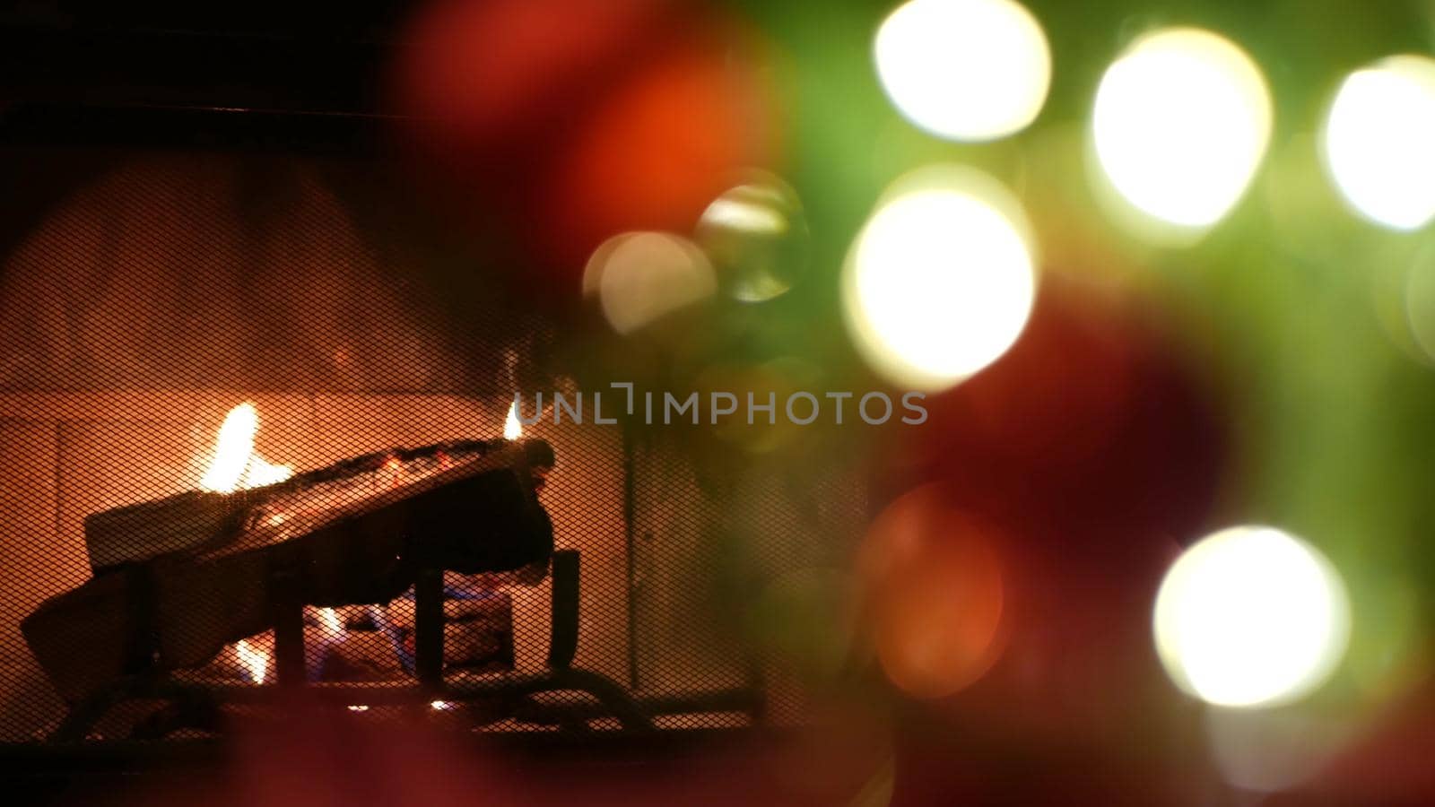 Christmas tree lights by fire in fireplace, New Year or Xmas decoration of pine. by DogoraSun