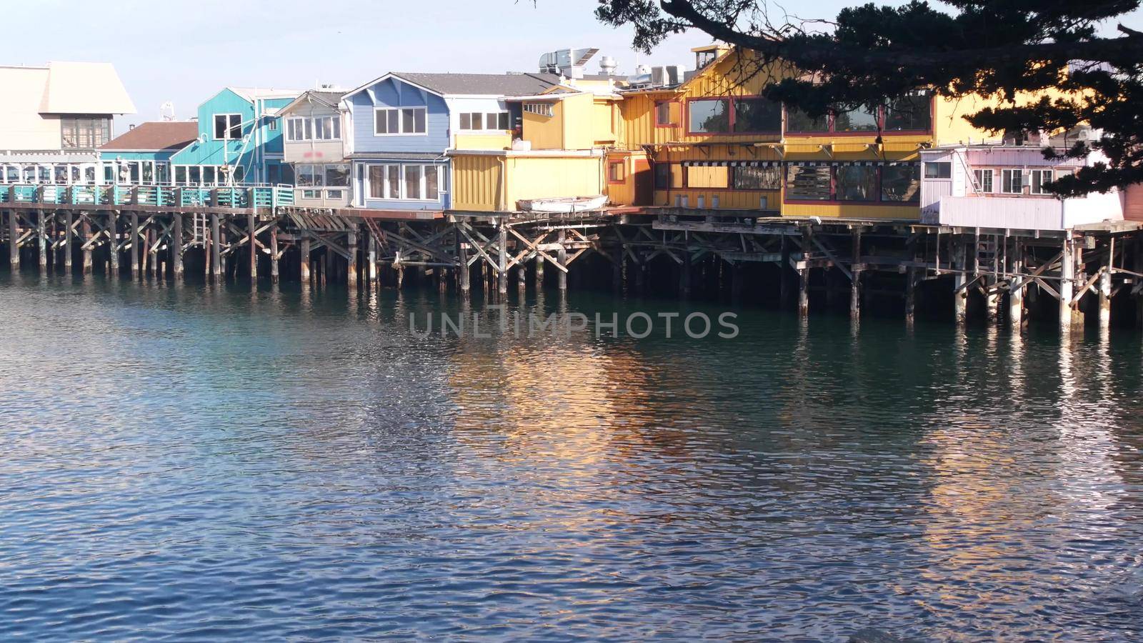 Colorful wooden houses on piles or pillars, Old Fisherman's Wharf, Monterey bay. by DogoraSun
