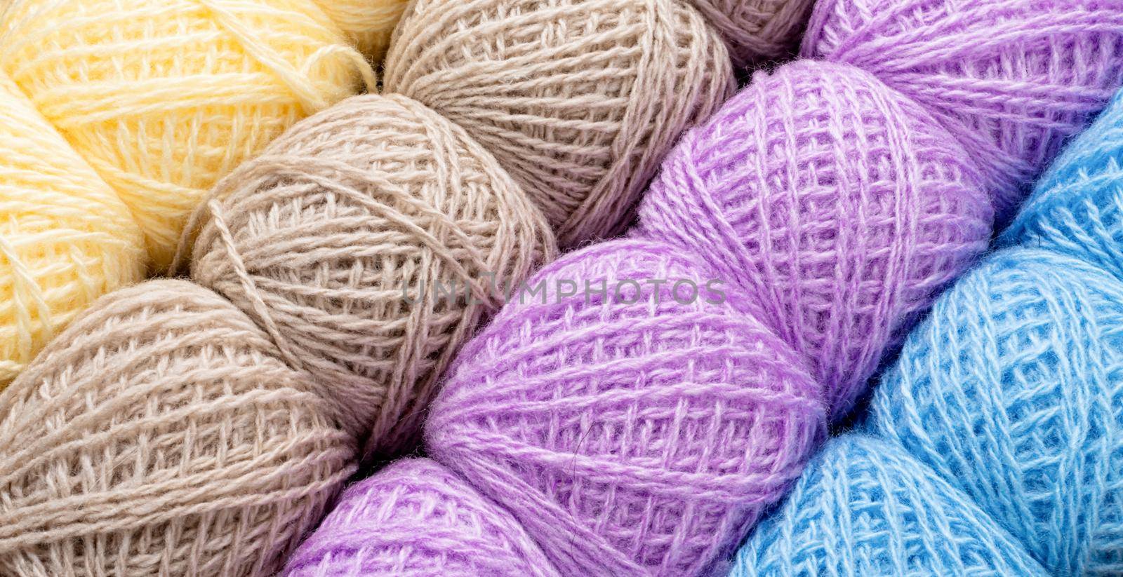 Knitting needles, colorful threads. Selection of pastel colored yarn wool on shopfront. Knitting background, a lot of balls. Knitting yarn for handmade winter clothes