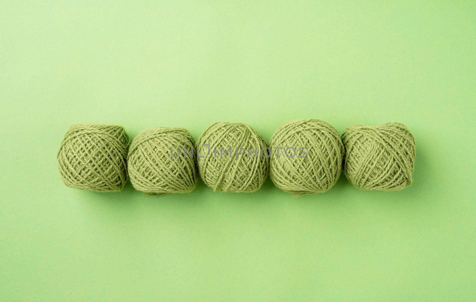 bright green yarn wool in a raw on bright background, top view flat lay by Desperada