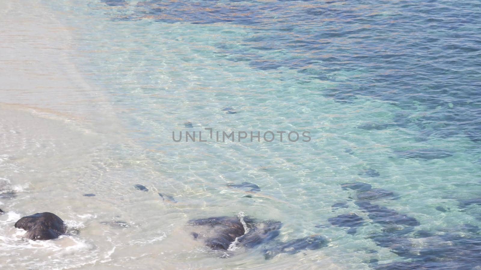 Crystal blue azure transparent ocean, La Jolla cove, California coast, USA. Turquoise translucent clear sea waves from above. Rippled water surface, tropical beach paradise lagoon, summer vacations.
