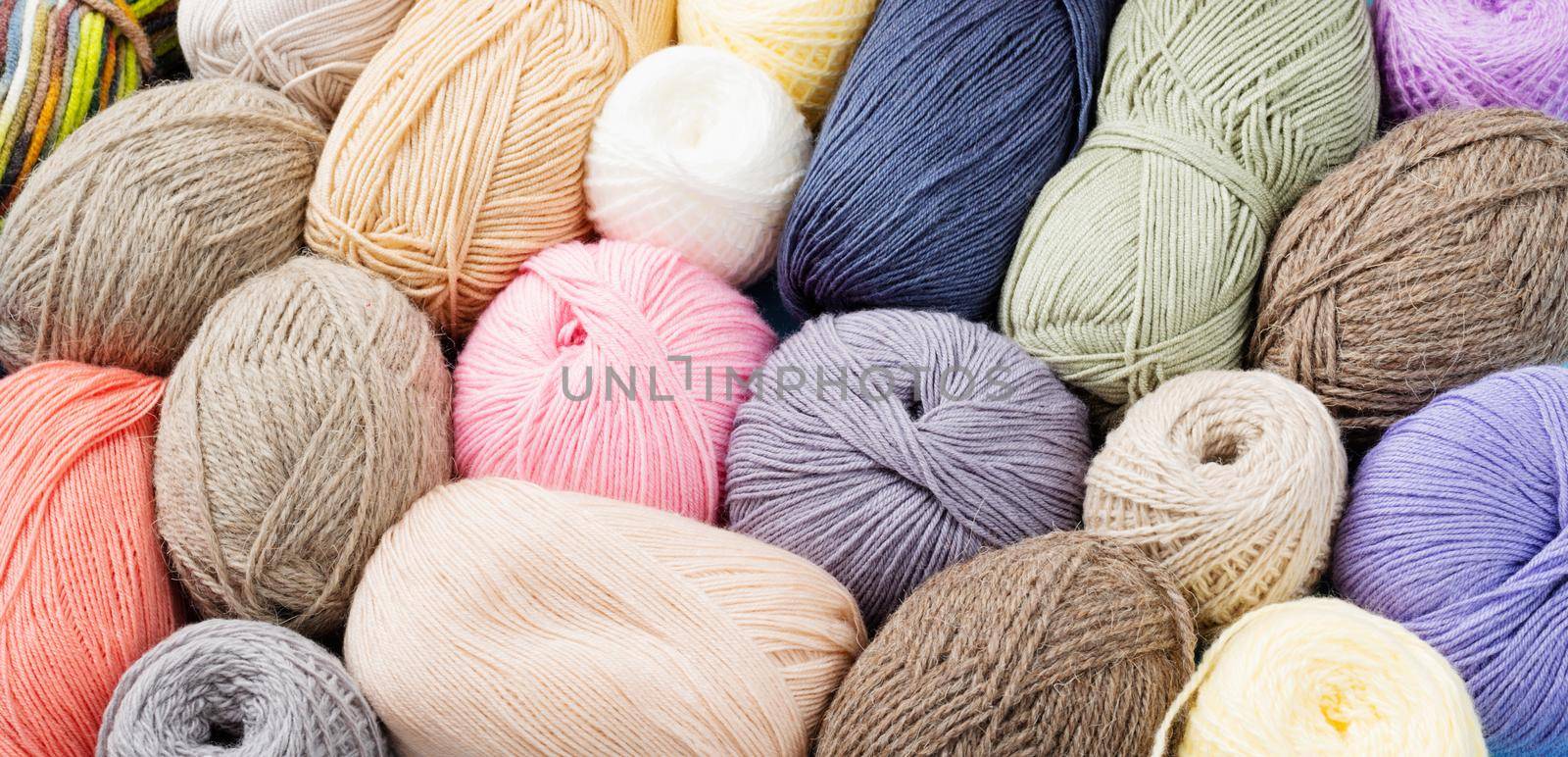 pastel colored yarn wool on shopfront. Knitting background, a lot of balls. Knitting yarn for handmade winter clothes by Desperada