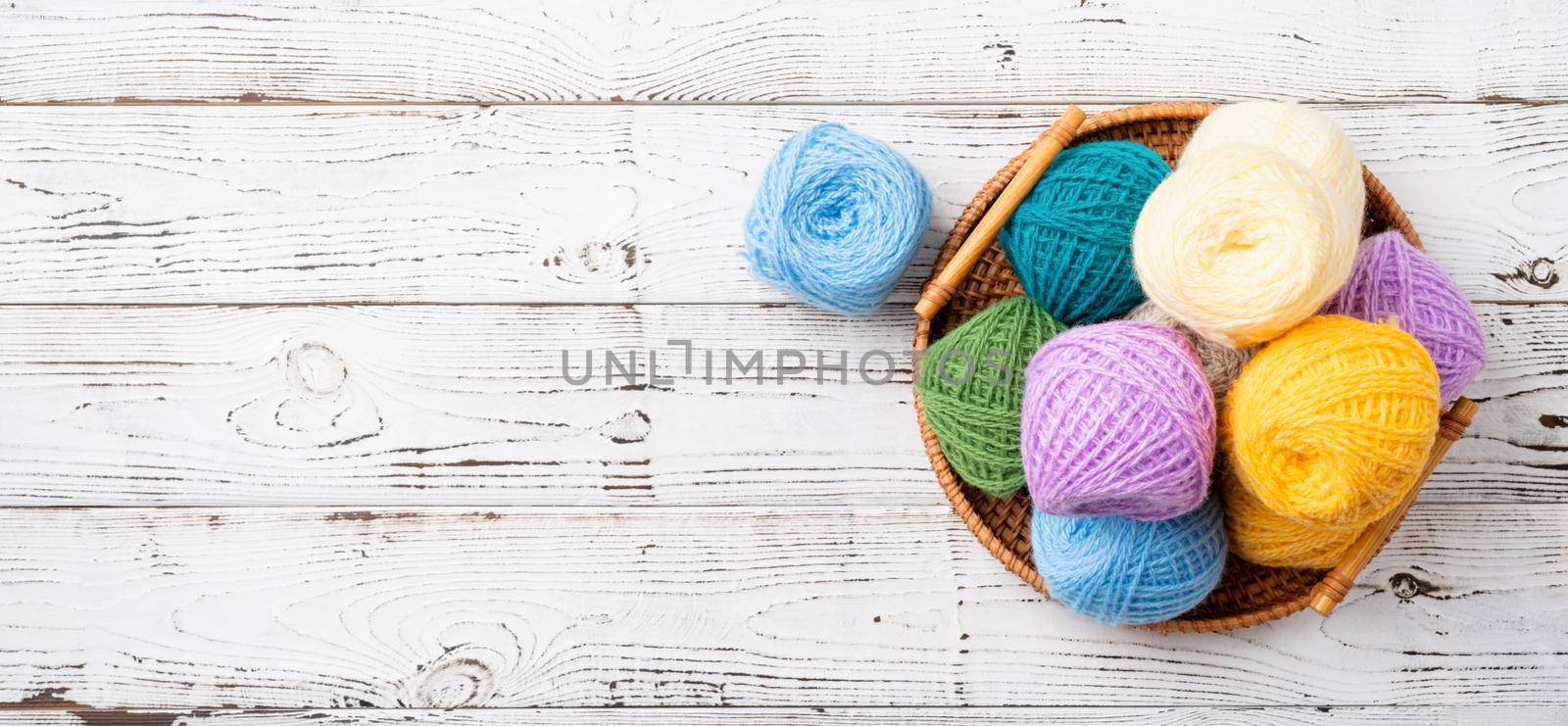 bright colorful yarn wool in a basket on wooden background by Desperada