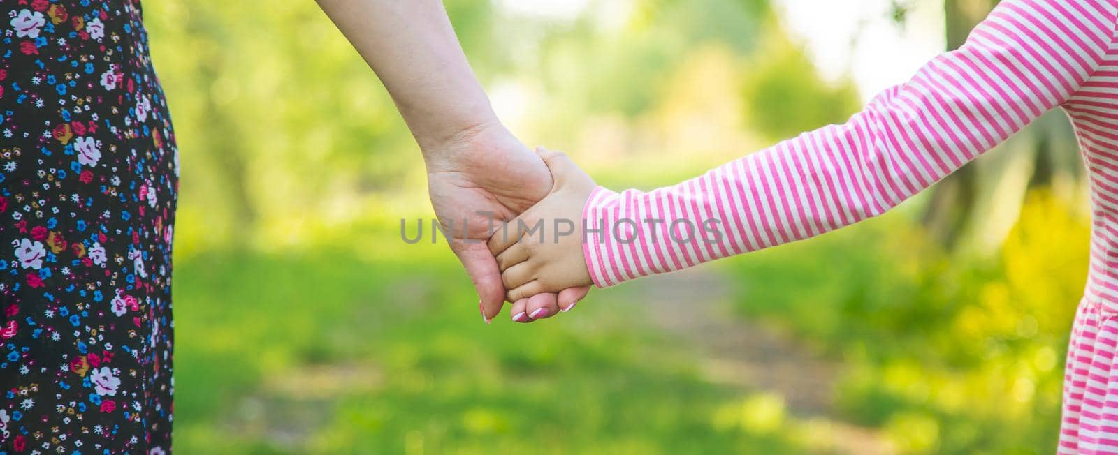 A child with his mother goes by the hand. Selective focus. nature.