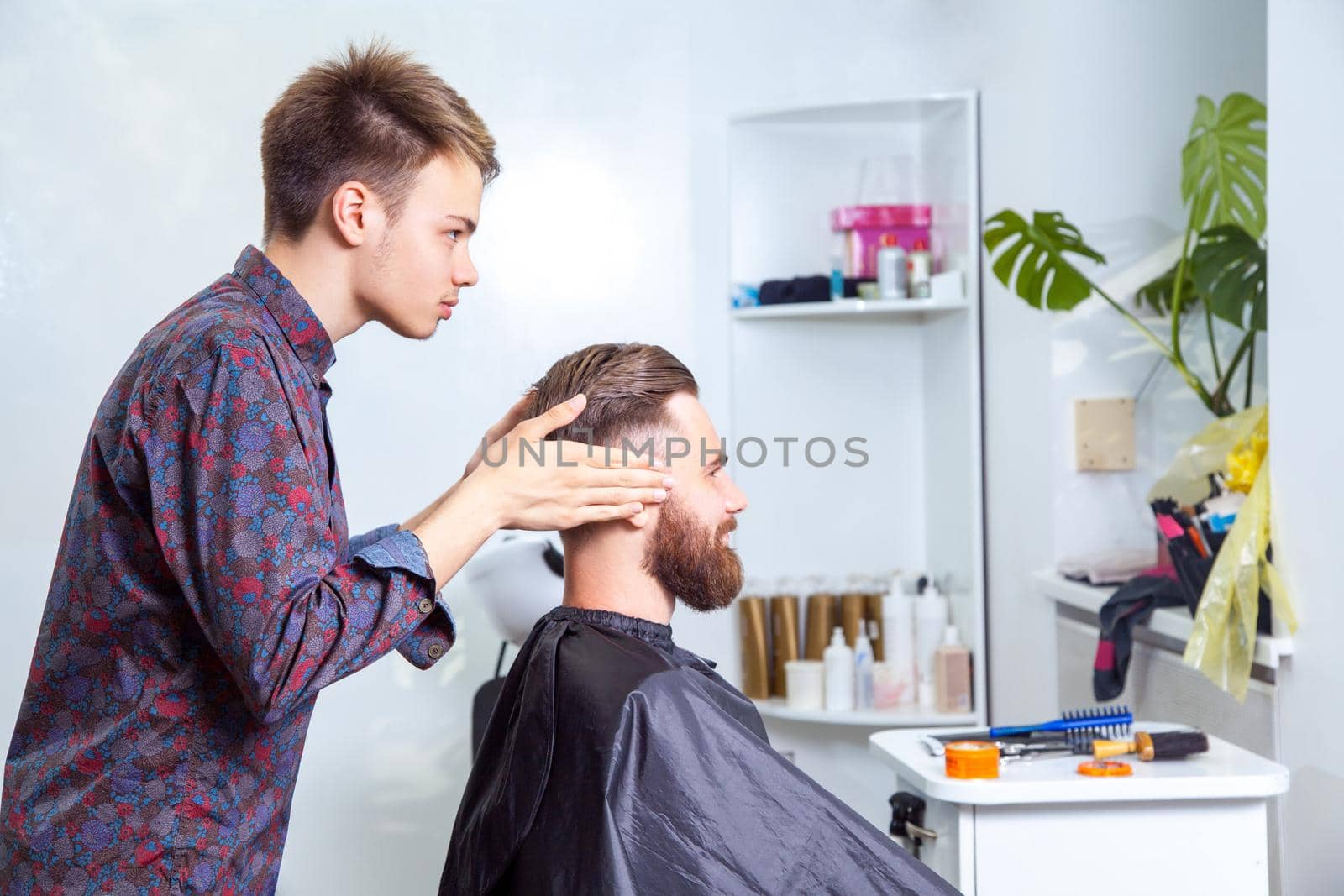 fashion barber making undercut style for his client.