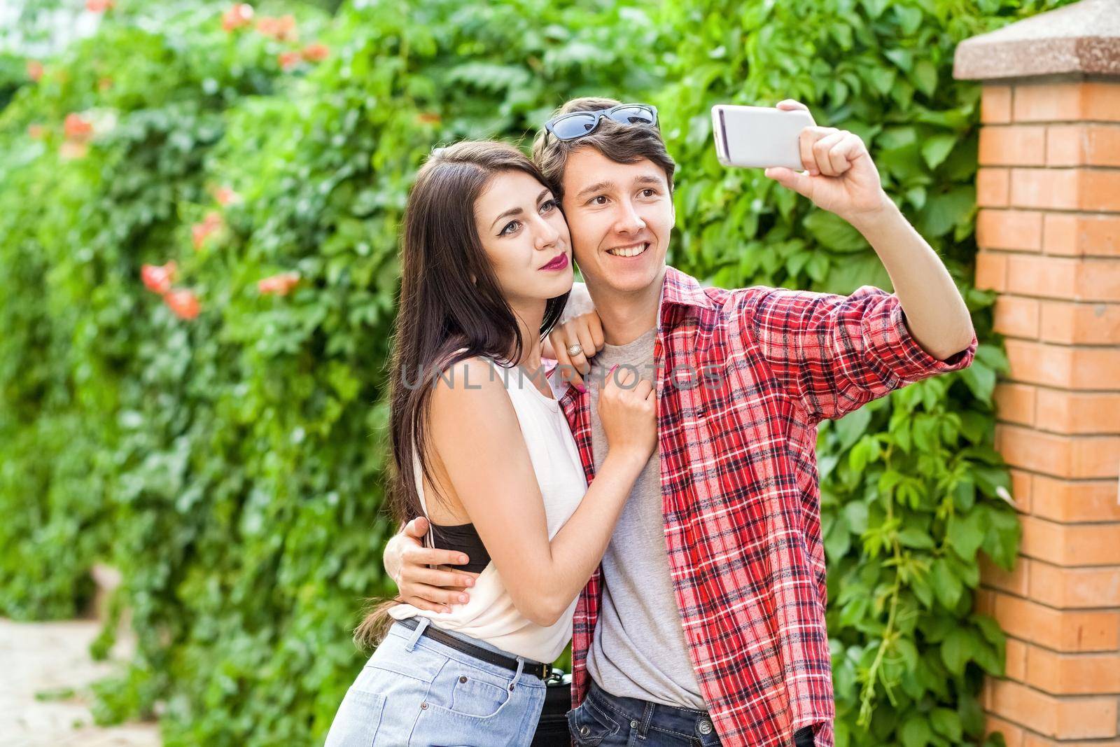 Happy beautiful couple taking a selfie on a mobile phone. huging and have a fun together.