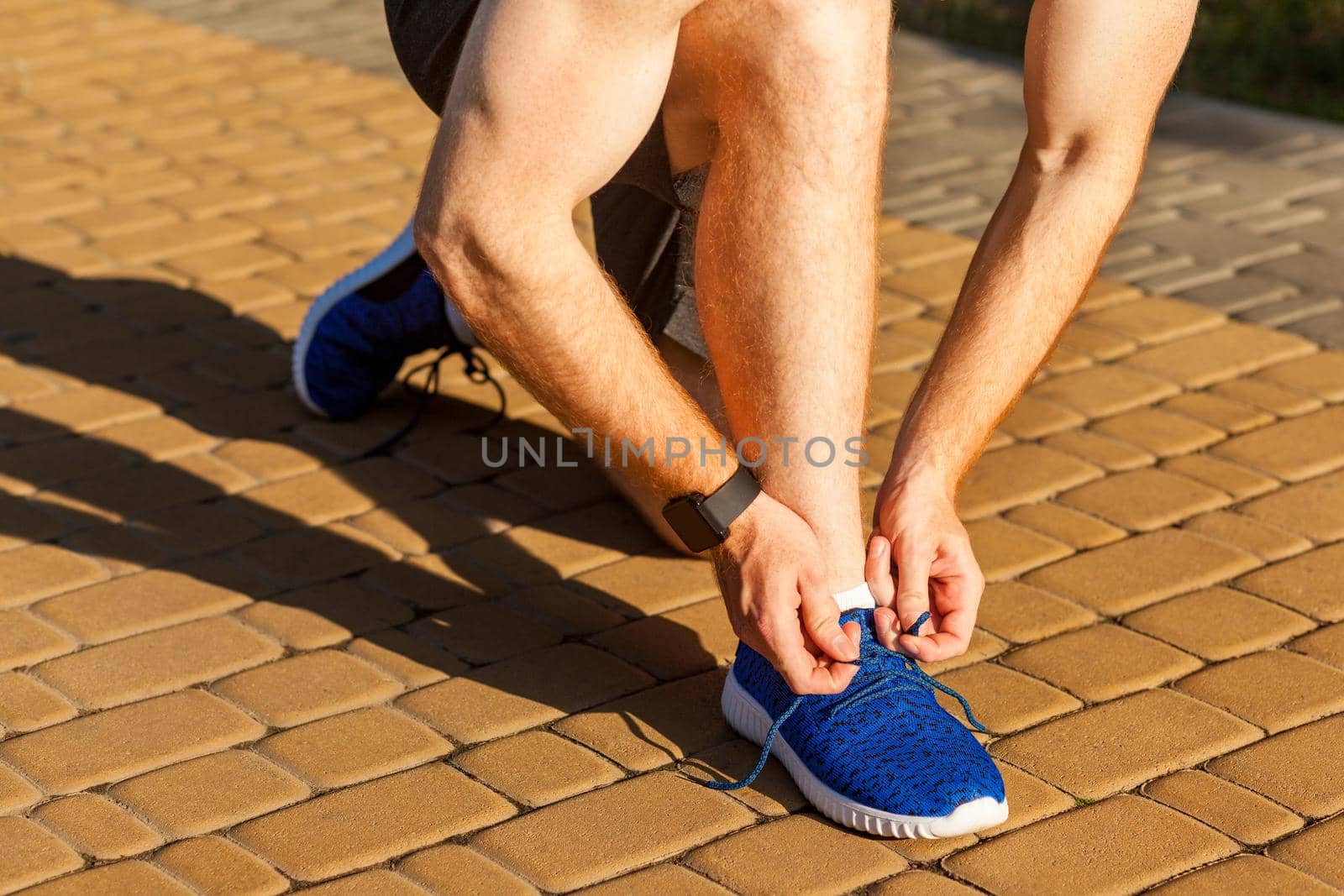 Tie shoelaces. Blue sneakers. Runnig. Pause