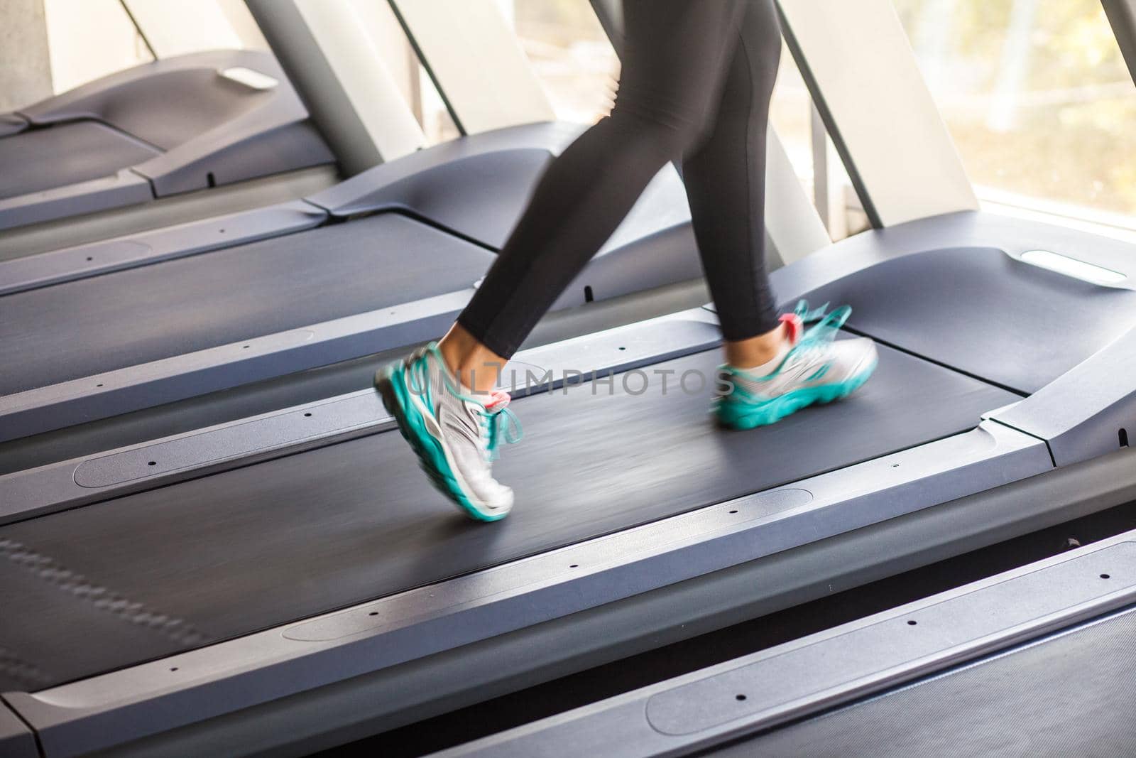 Closeup legs incognito runner on racetrack. Studio shot