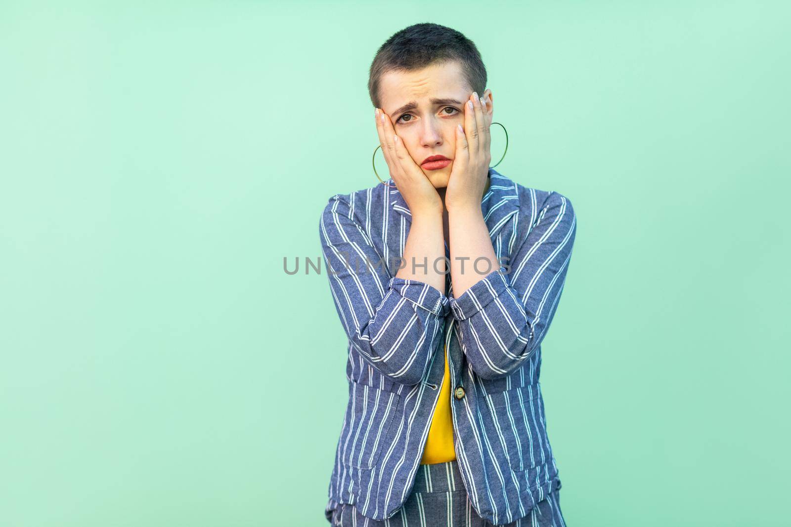 Emotional young woman with short hair on light green background by Khosro1