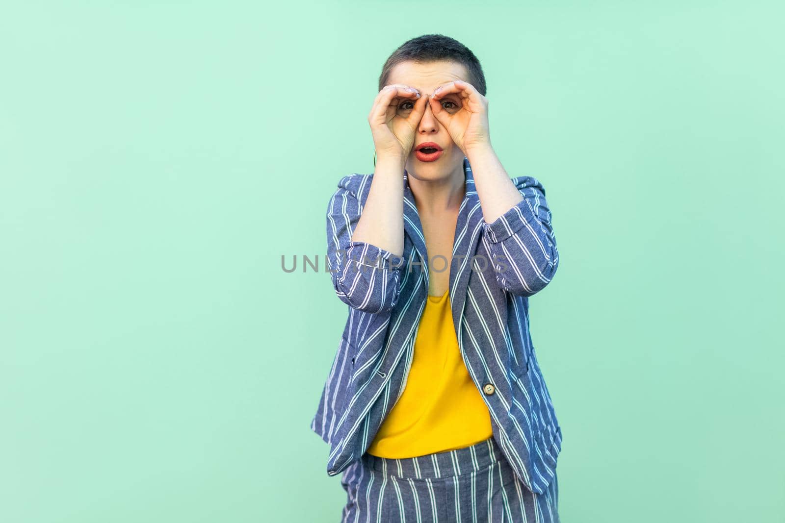 Emotional young woman with short hair on light green background by Khosro1