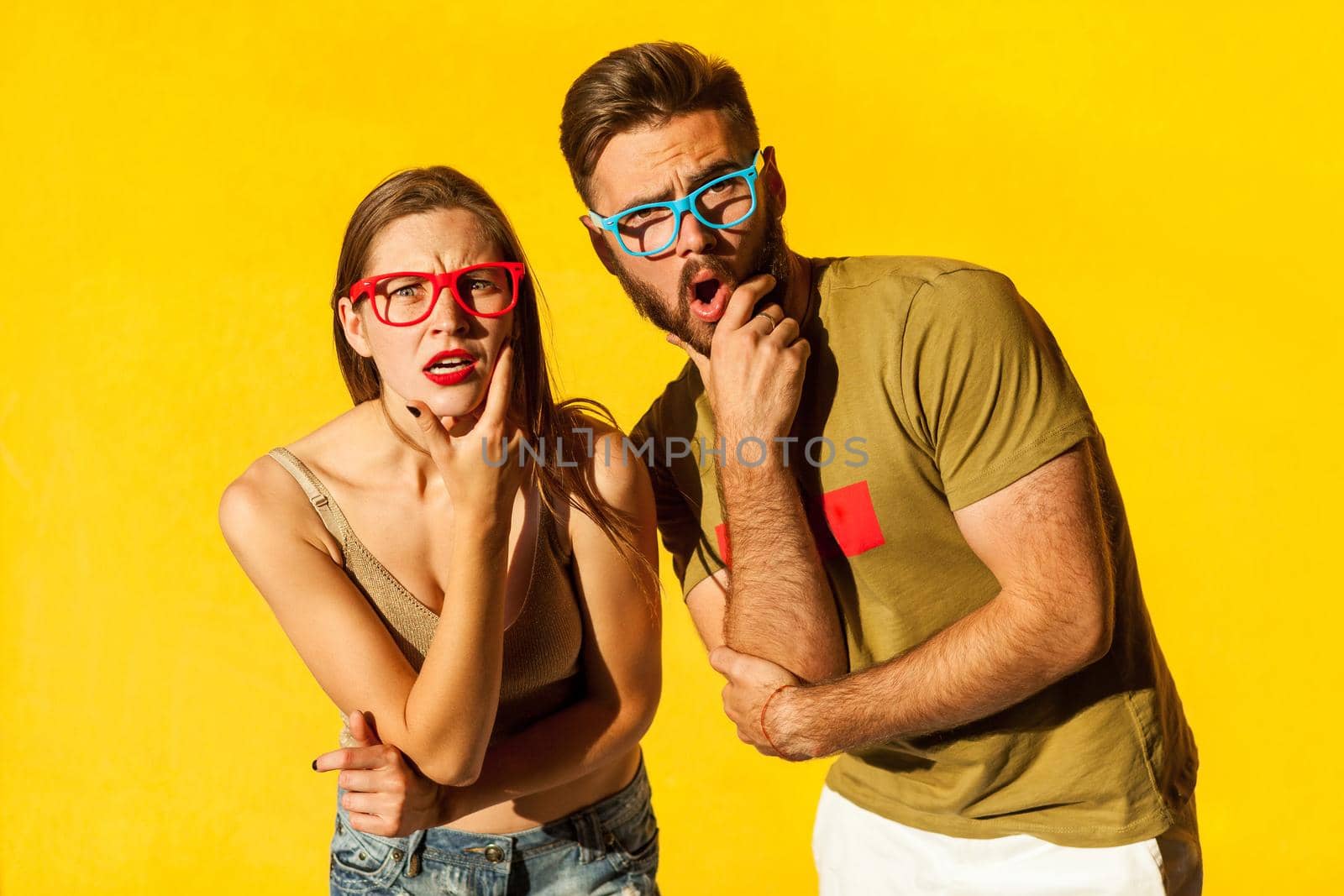 What?! People emotions and feelings. Handsome young adult hipsters, looking at camera with wonder face. Yellow wall, outdoor