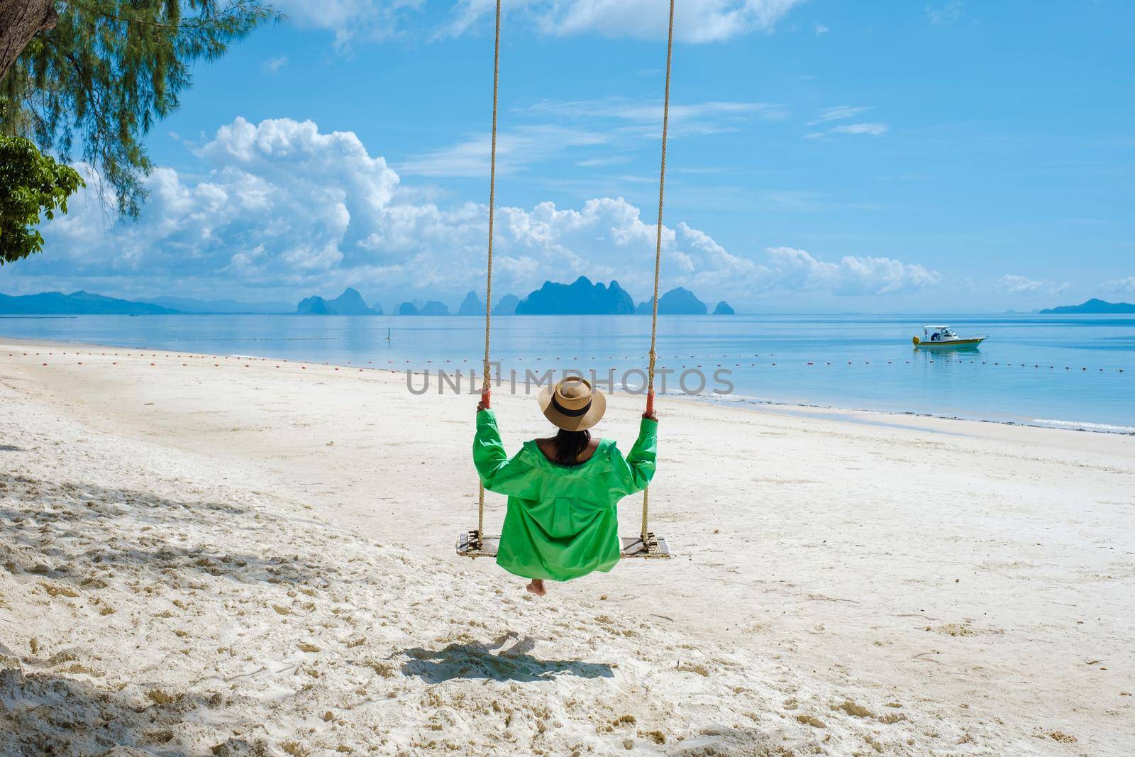 couple men and woman on the beach of the tropical Island Naka Island near Phuket Thailand by fokkebok