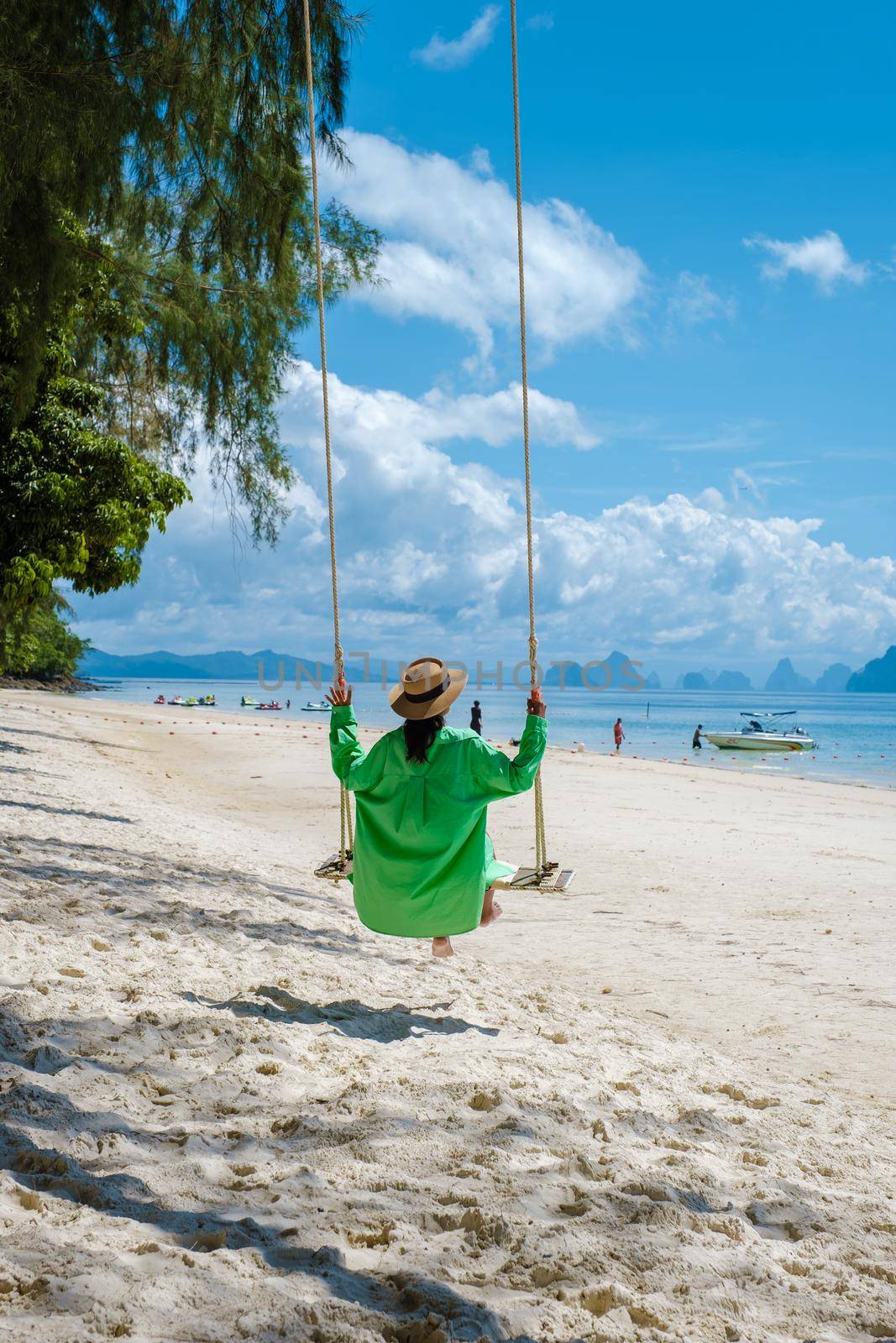 couple men and woman on the beach of the tropical Island Naka Island near Phuket Thailand by fokkebok