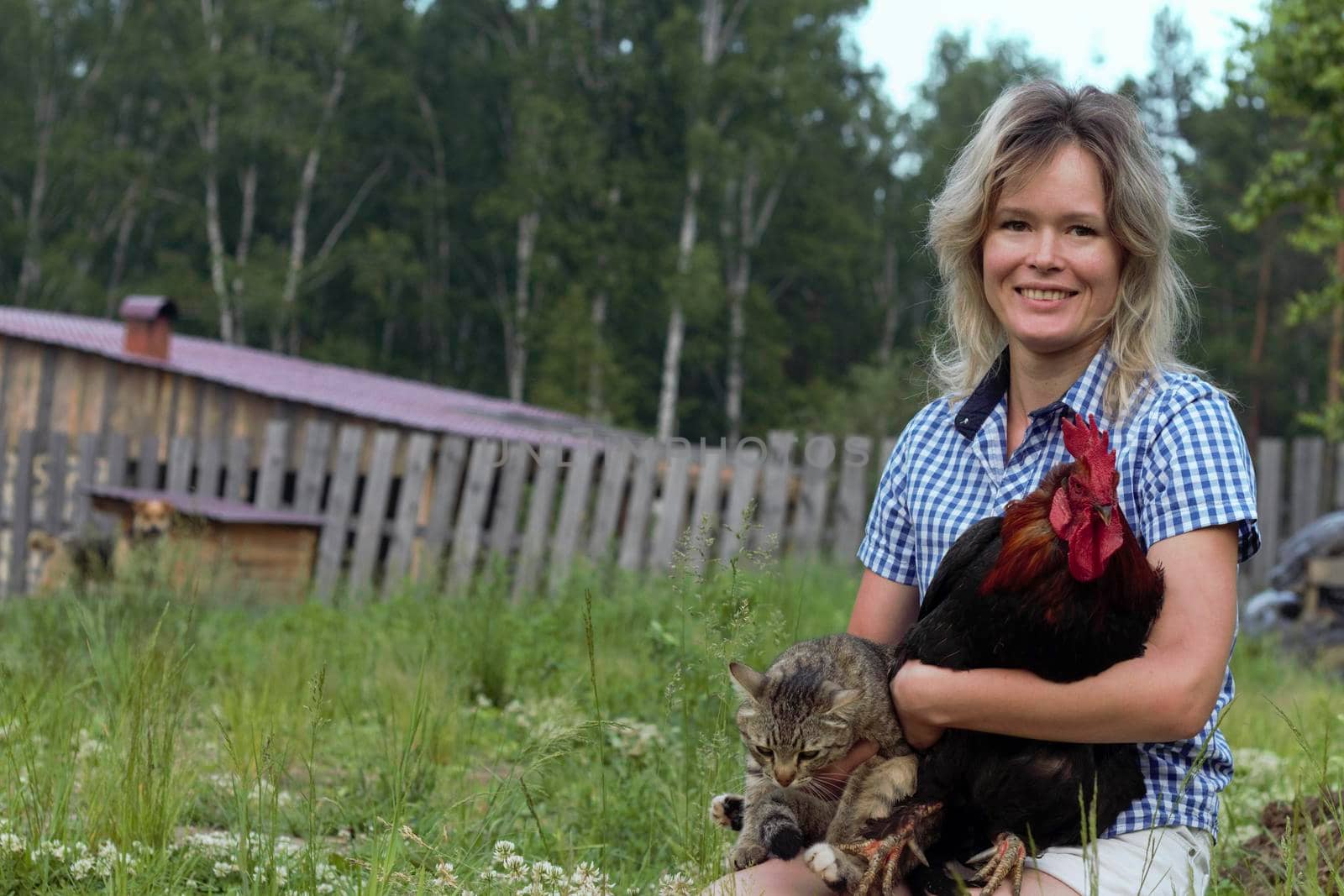 Beautiful woman in the farm holding a chicken, healthy lifestyle by AleksandraLevkovskaya